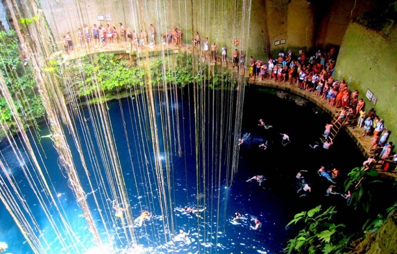 Turistas contemplando cenote em Tulum